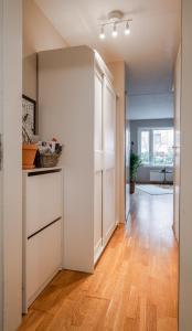 una cucina a pianta aperta con armadi bianchi e pavimenti in legno massello di Beautiful home in the heart of Oslo (Grünerløkka) a Oslo
