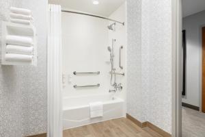 a bathroom with a tub and a shower with towels at Hampton Inn Columbia, MD in Columbia
