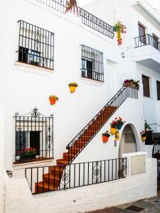 un edificio blanco con escaleras y macetas de flores en Escuela Village, en Marbella