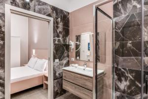 ein Bad mit einem Waschbecken und einem Spiegel in der Unterkunft Rafilina's House in Neapel