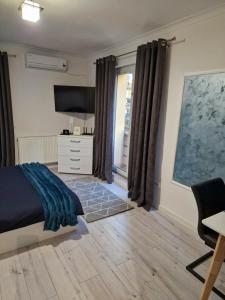 1 dormitorio con 1 cama, TV y escritorio en Cazare Andreea, en Cluj-Napoca