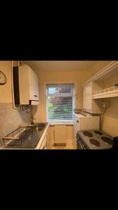 a kitchen with a stove and a sink and a window at 2 bed full house with private summer garden in Elswick