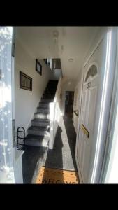 a hallway of a house with a white door and stairs at 2 bed full house with private summer garden in Elswick