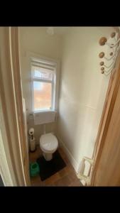 a small bathroom with a toilet and a window at 2 bed full house with private summer garden in Elswick