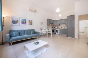 a living room with a blue couch and a table at Pageant Homes in Nicosia