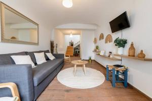 ein Wohnzimmer mit einem Sofa und einem Tisch in der Unterkunft Home near Évora's main square with private terrace in Évora