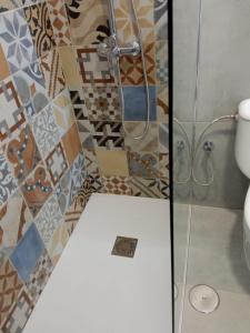 a bathroom with a shower with a toilet and tiles at Cosy Studio on rooftop Playa Paraiso in Playa Paraiso