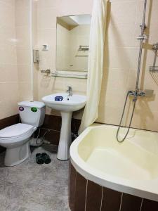a bathroom with a sink and a toilet and a bath tub at ObodHotel in Dushanbe