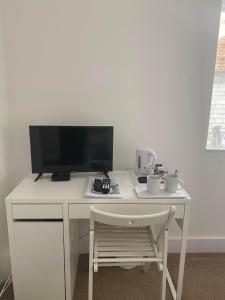 a white desk with a computer monitor and a chair at Cadgwith Cove Inn in Cadgwith