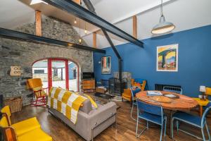 - un salon avec des murs bleus, une table et des chaises dans l'établissement Marianne Cottage, à Ráistín