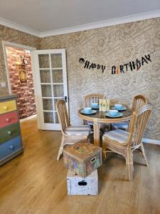 a dining room with a happy birthday sign on the wall at Harry Potter Hogwarts apartment in Leavesden Green