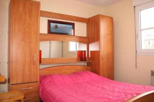 um quarto com um beliche e um cobertor rosa em 524 - A ERQUY, Immeuble tranquille CAP ARMOR située à 200M de la plage em Erquy