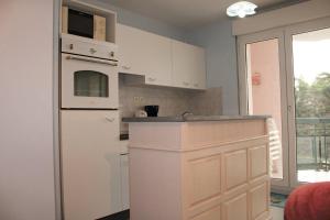 uma cozinha com armários brancos e um frigorífico branco em 524 - A ERQUY, Immeuble tranquille CAP ARMOR située à 200M de la plage em Erquy