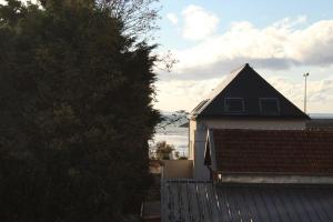 uma casa branca com um telhado preto e uma árvore em 524 - A ERQUY, Immeuble tranquille CAP ARMOR située à 200M de la plage em Erquy
