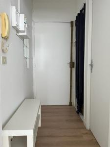 um quarto branco com um banco branco e uma porta em Le Central - Studio avec terrasse Camas,Timone em Marselha