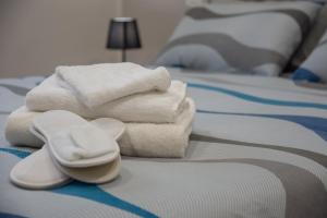 stos ręczników i ręczników na łóżku w obiekcie Maison Noel w mieście Cava deʼ Tirreni