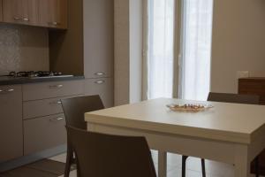 a kitchen with a table with chairs and a bowl of fruit at Maison Noel in Cava deʼ Tirreni