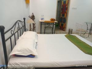 1 dormitorio con 1 cama con sábanas y almohadas blancas en The King's Castle en Guwahati