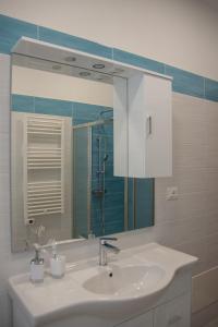 W łazience znajduje się umywalka i lustro. w obiekcie Maison Noel w mieście Cava deʼ Tirreni