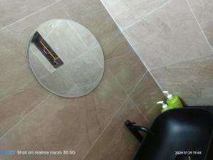 um espelho redondo no chão de uma casa de banho em The King's Castle em Guwahati