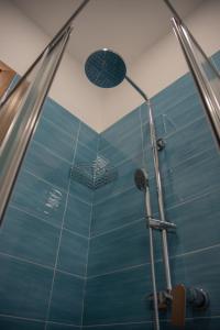 W łazience z niebieską ścianą znajduje się prysznic. w obiekcie Maison Noel w mieście Cava deʼ Tirreni