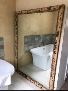 un bagno con specchio che riflette una vasca. di Hermanus 13 on 2nd Guest Rooms a Hermanus