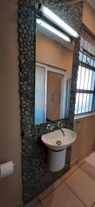 een badkamer met een wastafel en een spiegel bij Maerua Mall Luxe Accommodations 3rd Floor in Windhoek