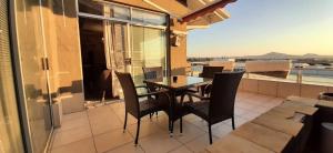 een patio met een tafel en stoelen op een balkon bij Maerua Mall Luxe Accommodations 3rd Floor in Windhoek