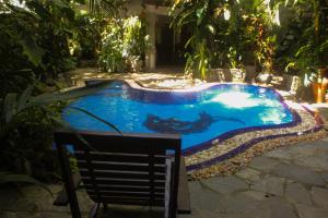 a swimming pool in a yard with a chair next to it at Villa Olde Ceylon in Kandy