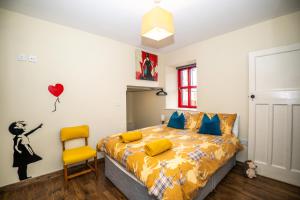 a bedroom with a bed and a yellow chair at Marianne Cottage in Ráistín