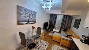 uma sala de estar com uma mesa e um sofá em Luxury Apartment Santorini em Skopje
