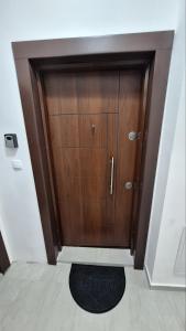 uma grande porta de madeira num quarto com um tapete em Luxury Apartment Santorini em Skopje