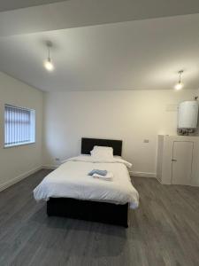 een slaapkamer met een groot bed met witte lakens bij VicVic Guest house in Oldham