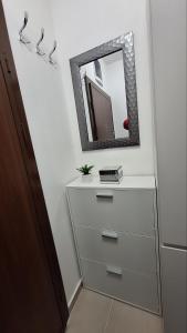 uma cómoda com um espelho na parede em Luxury Apartment Santorini em Skopje