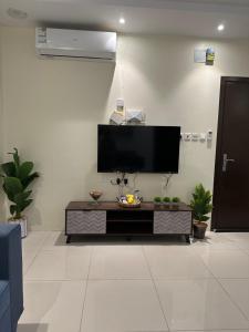 sala de estar con TV de pantalla plana en la pared en شقة مفروشة غرفتين بدخول ذاتي en Al Kharj