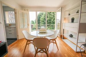 een eetkamer met een tafel en stoelen en een raam bij Apartment with balcony, parking and elevator in Lille