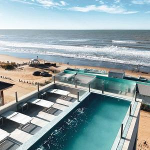 una piscina su una spiaggia vicino all'oceano di Pinamar Beach Resort a Pinamar