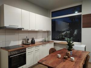 cocina con armarios blancos y mesa de madera en Andris Apartments en Stuttgart