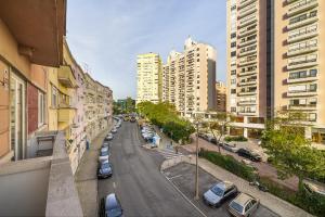 ulica miejska z zaparkowanymi samochodami i budynkami w obiekcie WHome Mid-Term Marvel: Your Home Away from Home w Lizbonie