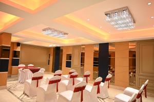 a conference room with white chairs and a table in the middle at Hotel Trax International in Jamshedpur