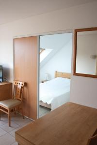 um quarto com uma cama, uma cadeira e um espelho em Residence Le Royal Golf & Horse em Mooslargue