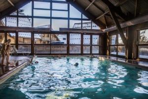a large swimming pool with people in the water at CHALET DES PAZ in Le Dévoluy