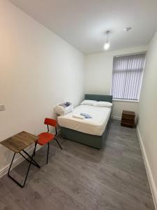 ein Schlafzimmer mit einem Bett, einem Tisch und einem Stuhl in der Unterkunft Vic Vic property in Oldham