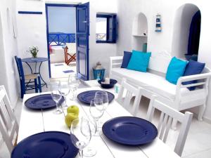 un comedor con platos azules en una mesa en Blu Bianco Cave House by SV, en Oia