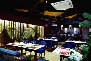 a dining room with tables and blue chairs at Hotel Trax International in Jamshedpur