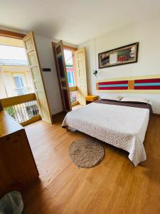 1 dormitorio con 1 cama y suelo de madera en Hostal Don Jose, en Santa Rosa de Cabal