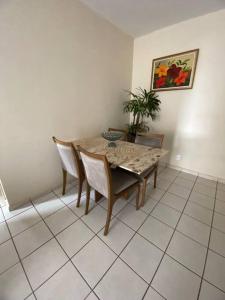 uma sala de jantar com mesa e cadeiras e uma planta em Apt confortável perto do centro em Palmas