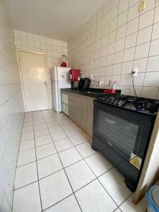 a small kitchen with a stove and a refrigerator at Apt confortável perto do centro in Palmas