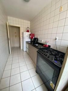 uma pequena cozinha com um fogão e um frigorífico em Apt confortável perto do centro em Palmas