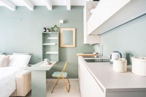 cocina blanca con fregadero y cama en Bergamo Center [SUITE MIA] - Modern & Green + WiFi, en Bérgamo